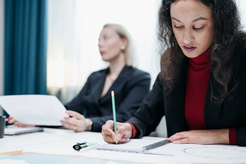 Persona che scrive su un taccuino durante una sessione di strategia.